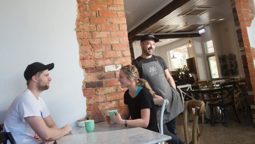 Adam Nicoletti in his cafe, Spring Gully General Store, with customers Rhys Hobbs and Belle Harrington. Photo: Darren Howe